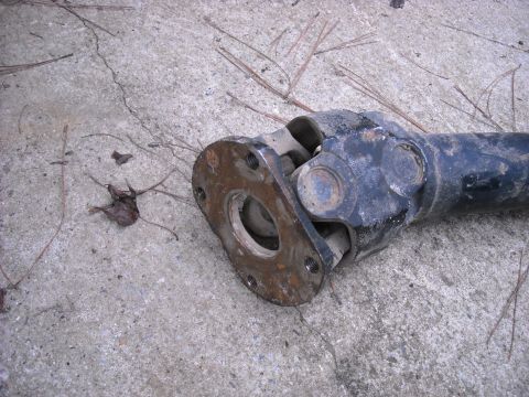 1979 Ford F-150 - Close-up of a driveshaft component resting on a concrete surface.