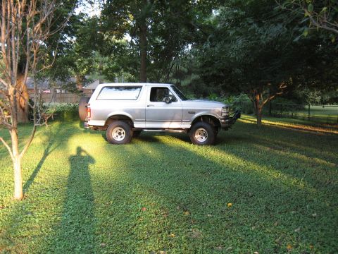 1994 Ford Bronco - Silver 1994 Ford Bronco parked on a green lawn during the day.