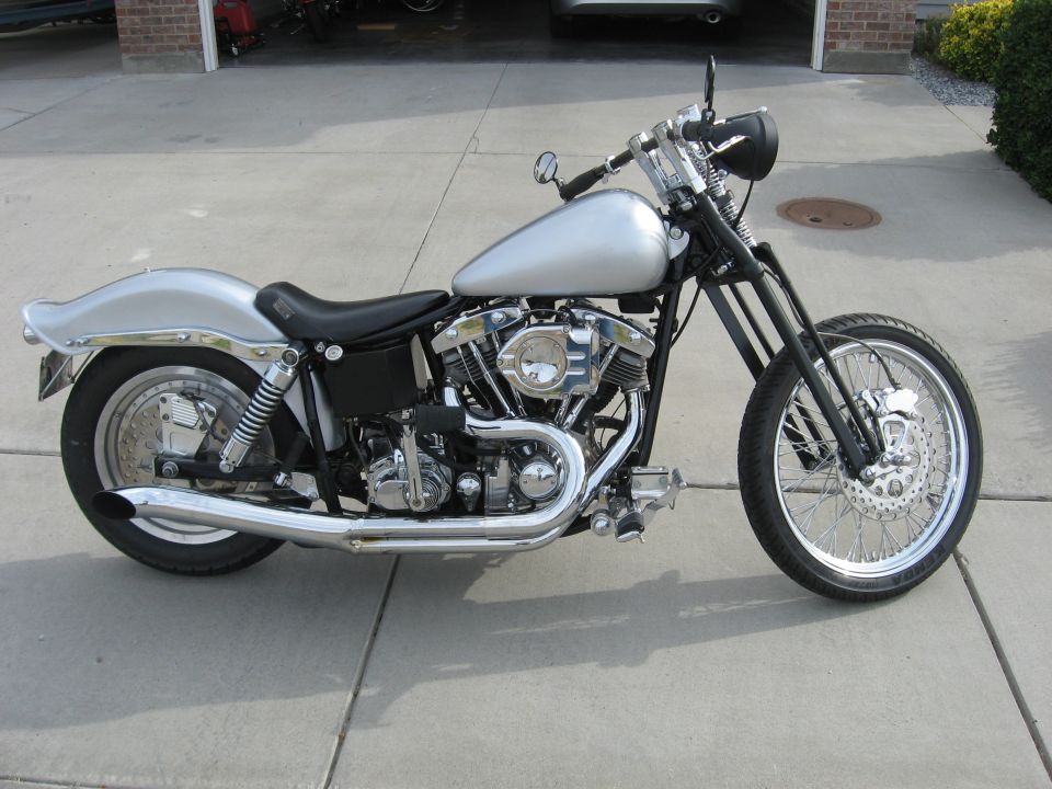 Silver custom Harley-Davidson chopper motorcycle parked on driveway