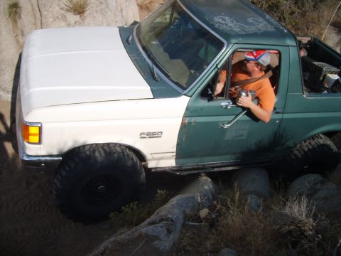 1989 Ford Bronco - This two-tone Ford F-250 is navigating a rocky trail with a driver behind the wheel.