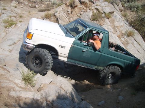 1989 Ford Bronco - A modified Ford F-250 navigates a rocky trail, demonstrating its off-road capabilities.