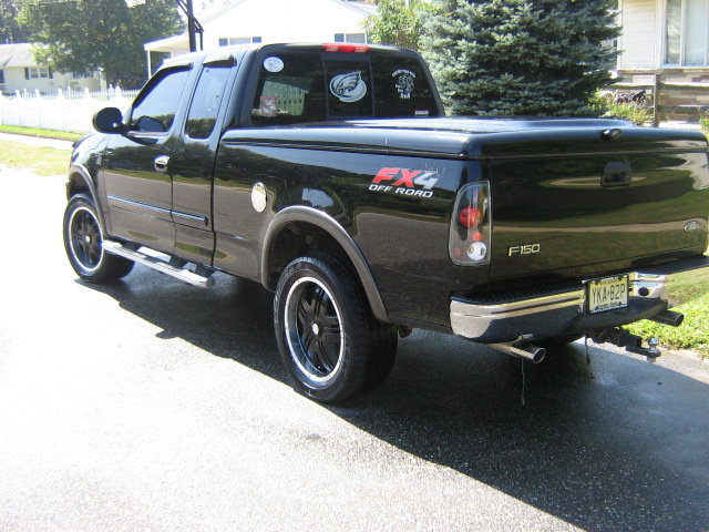 Black 2002 Ford F-150 pickup truck with FX4 Off Road badging and custom wheels