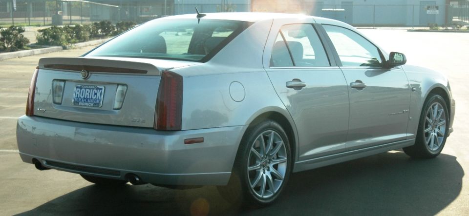 Silver Cadillac STS sedan rear 3/4 view with lip spoiler and dual exhaust tips