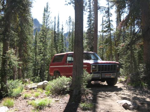 1981 Ford Bronco - Red 1981 Ford Bronco parked on a forest road.