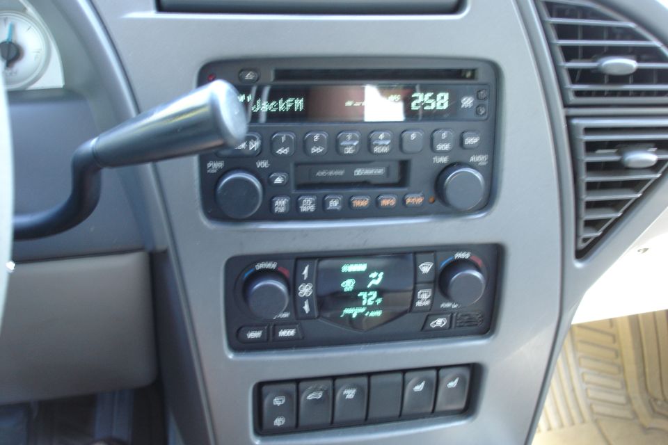 Gray center console radio and climate controls of a GM vehicle interior