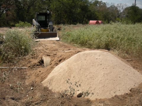 1996 Ford Bronco - A skid steer loader is positioned on a dirt path at a construction site.
