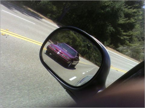 1992 Ford Crown Victoria - Reflection of a purple sedan in a side mirror on a sunny day.