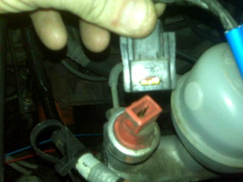 1995 Ford Bronco - Close-up of electrical connectors and a reservoir in a vehicle's engine bay.