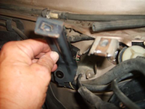 1993 Ford Crown Victoria - Close-up view of engine bay components with a hand holding a bracket.