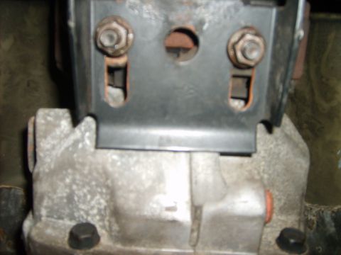 1993 Ford Crown Victoria - Metal transmission mount bracket attached to a transmission housing.