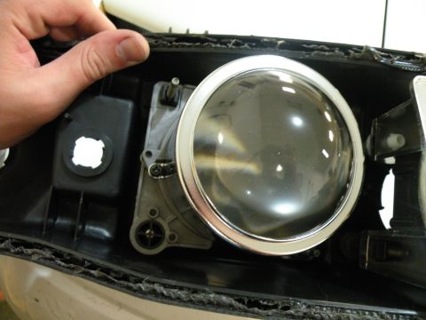 1998 Subaru Legacy - Close-up of a vehicle headlight assembly, showing internal components and a projector lens.