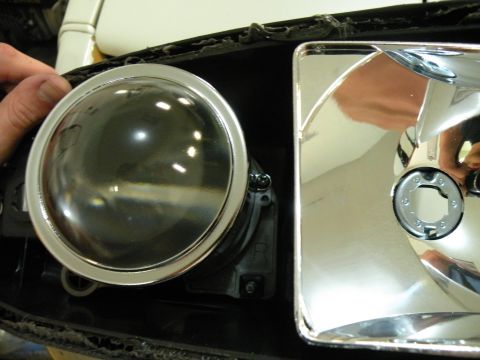 1998 Subaru Legacy - Close-up view of a vehicle's headlight assembly, showing a circular lens and chrome detailing.