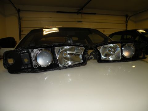 1998 Subaru Legacy - A pair of car headlights are displayed on a white surface, with a car's windshield visible in the background.