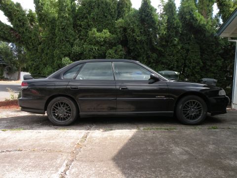 1998 Subaru Legacy - Side profile of a black 1998 Subaru Legacy sedan, showing its 'Limited' trim designation.