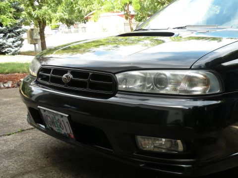 1998 Subaru Legacy - The front grille and headlights of a black Subaru Legacy are visible in this close-up shot.