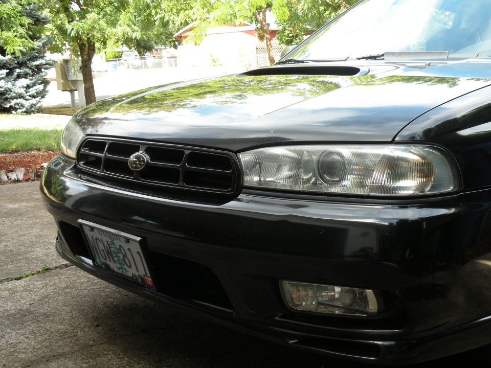 Front view of a black 1998 Subaru Legacy with a license plate reading WGH811