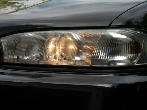 1998 Subaru Legacy - Close-up of the front headlight assembly on a 1998 Subaru Legacy.
