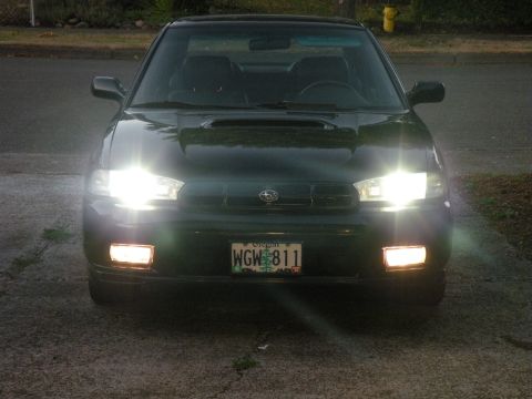 1998 Subaru Legacy - Front view of a dark green 1998 Subaru Legacy, its lights illuminating the driveway.