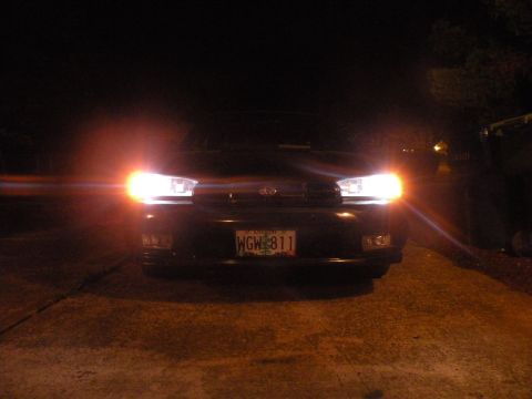 1998 Subaru Legacy - Front view of a black 1998 Subaru Legacy at night, illuminated by its headlights.