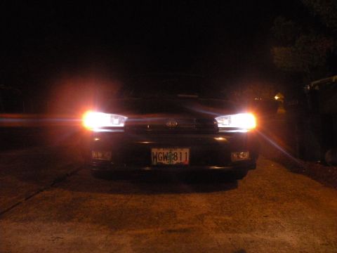 1998 Subaru Legacy - The front of a 1998 Subaru Legacy is visible at night, with its headlights illuminated and license plate WGW 811 displayed.