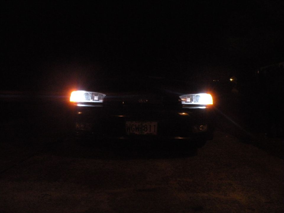 1998 Subaru Legacy front view at night, headlights on, license plate NGH 811 visible