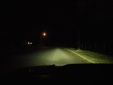 1998 Subaru Legacy - View from inside a vehicle at night, with headlights cutting through the darkness on a residential street.