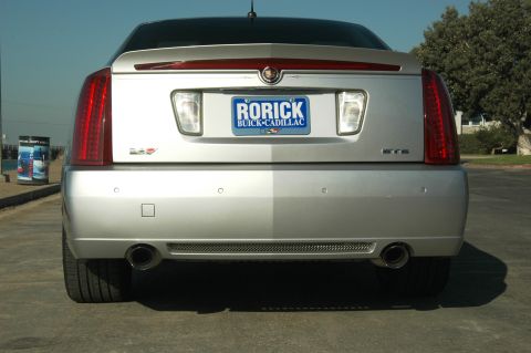 2006 Cadillac STS - The rear of a silver Cadillac STS sedan is visible, with its distinctive taillights and dual exhaust pipes.