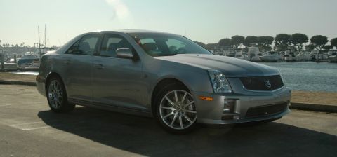 2006 Cadillac STS - Silver 2006 Cadillac STS sedan parked in a lot next to a marina with boats in the background.