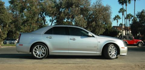 2006 Cadillac STS - A silver 2006 Cadillac STS is shown from the side, with a red Jeep and palm trees visible behind it.