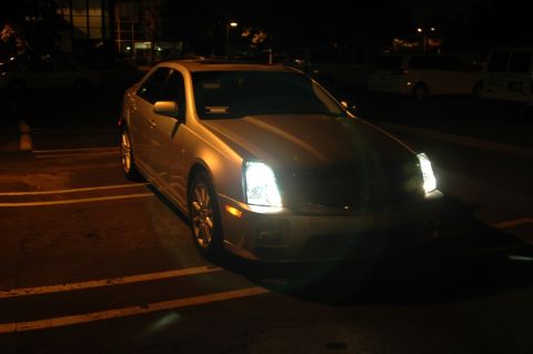 2006 Cadillac STS - 2006 Cadillac STS parked in a lot at night, headlights on.