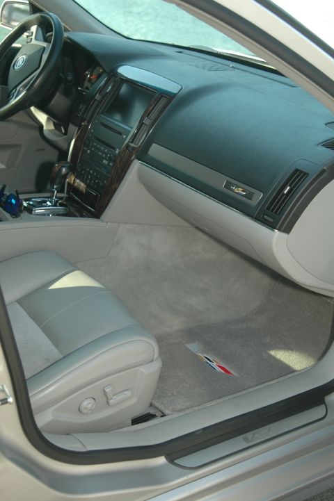 2006 Cadillac STS - The interior of the car features a wood-trimmed dashboard and a light-colored leather seat.