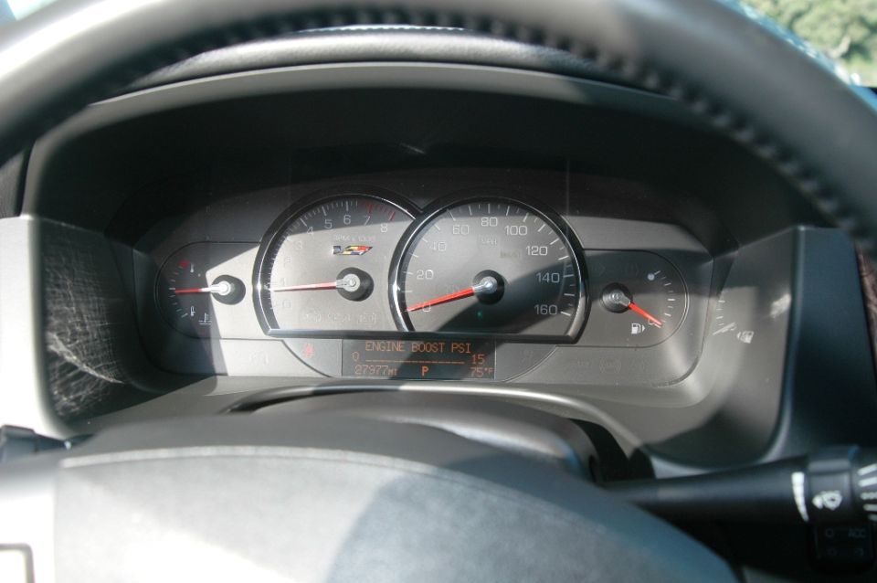 Cadillac gauge cluster showing engine boost PSI readout and 27,977 miles
