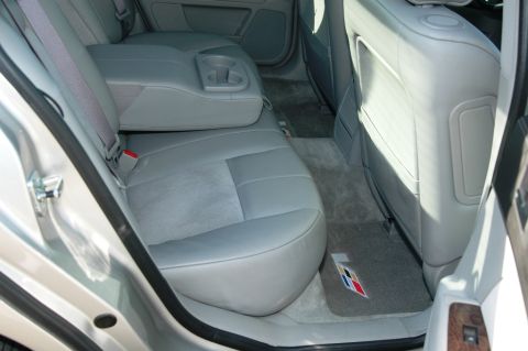 2006 Cadillac STS - The interior of a car shows gray leather seats and a floor mat with a distinctive emblem.