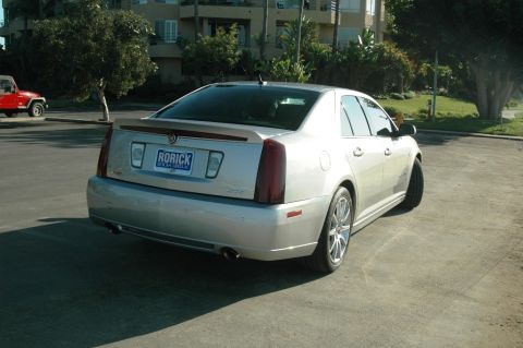 2006 Cadillac STS - The rear of a silver Cadillac STS is shown parked in a lot with a building in the background.