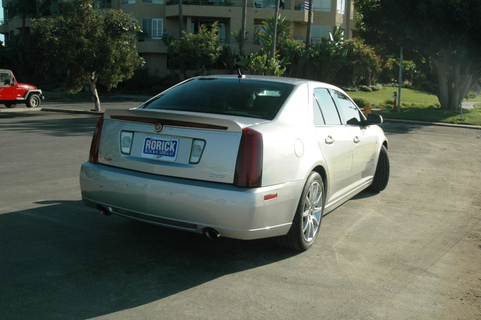 Silver Cadillac STS sedan from rear 3/4 angle parked on street