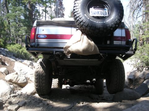 1991 Ford Bronco - This Ford Bronco is navigating a challenging, rocky off-road path.