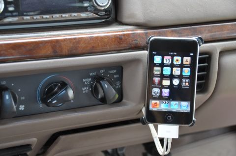 1996 Ford Bronco - Close-up of a car's interior, showing the climate control panel and a smartphone attached to an air vent.