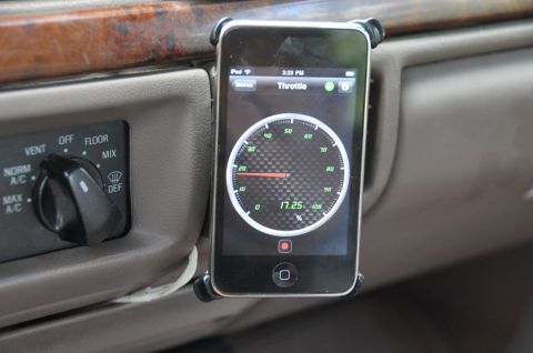 1996 Ford Bronco - An iPhone displays a throttle gauge app on the dashboard of a vehicle.