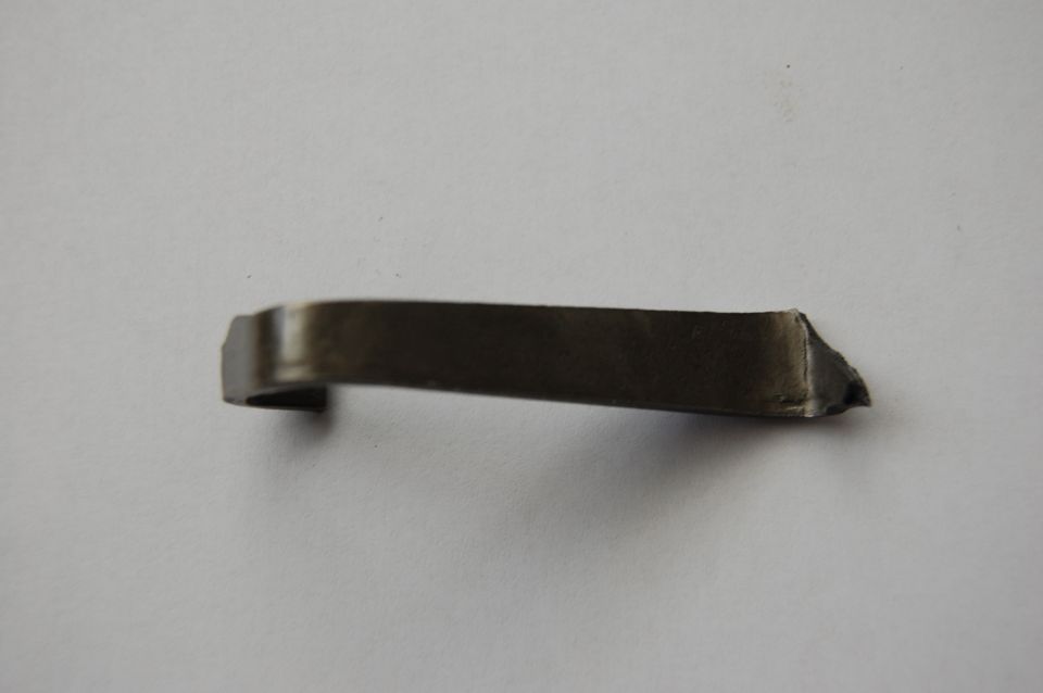 Metal clip on a white background. Supermotors.net logo in the corner