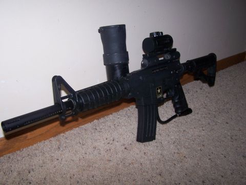 1986 Ford Bronco - A black paintball gun with tactical accessories is shown against a wall.