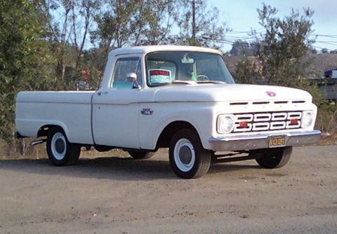 1984 Ford Bronco - This classic Ford pickup truck features a distinctive grille and a "FOR SALE" sign visible through the windshield.