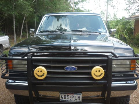 1990 Ford Bronco - This 1990 Ford Bronco features a prominent brush guard and distinctive yellow fog lights on its front grille.