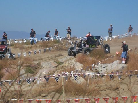 1993 Ford Bronco - An off-road buggy navigates a challenging course with spectators watching.