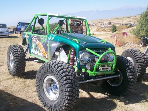 1993 Ford Bronco - This heavily modified off-road vehicle features a custom roll cage and oversized tires, suggesting it's built for extreme terrain.