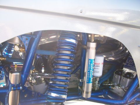 1993 Ford Bronco - Close-up view of the suspension system, highlighting the off-road racing shocks and intricate blue frame.