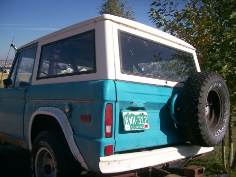 1972 Ford Bronco - The rear of a turquoise and white Ford Bronco is shown with a spare tire and a Colorado license plate.
