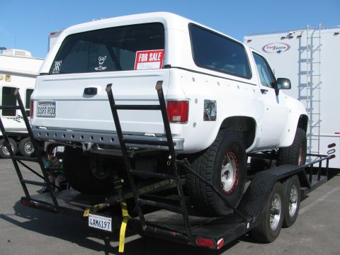1990 Ford Bronco - white lifted Chevrolet Blazer with off-road tires sits on a trailer bearing a For Sale sign and DIRT ROD plate.