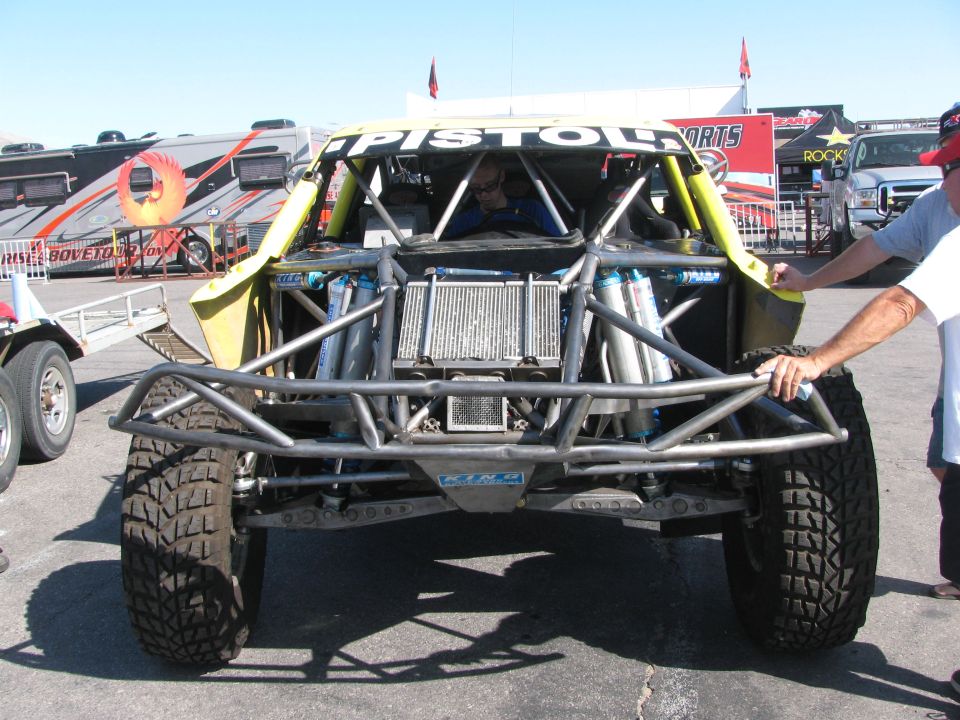 Front of a yellow tube-chassis off-road race truck with exposed radiator