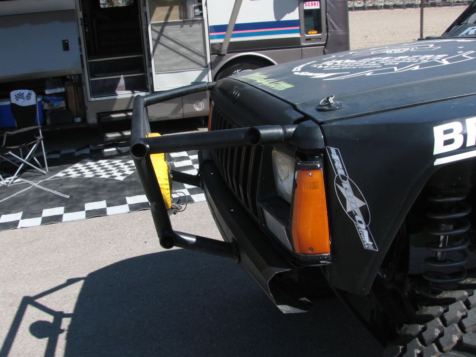 Close-up of black off-road vehicle front fender, brush guard, and headlight