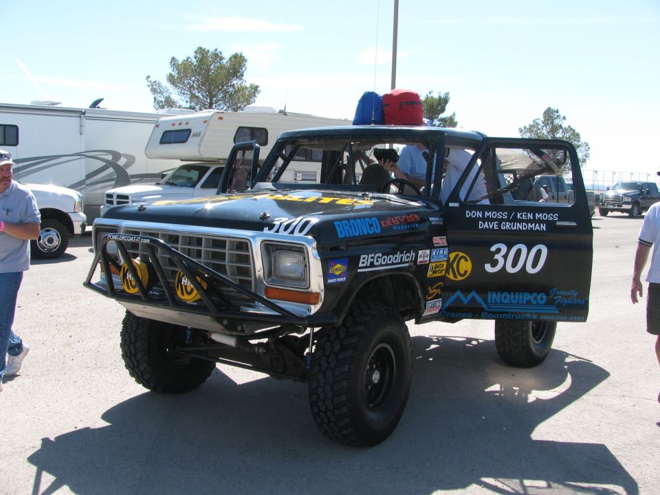 Black Ford Bronco race truck #300 with brush guard and KC lights in pit